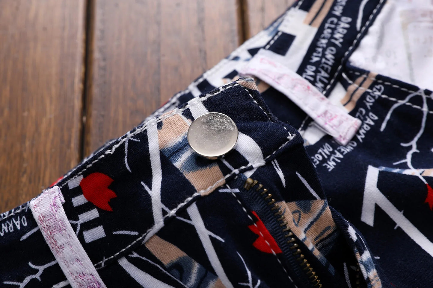 Close-up of a patterned fabric with a button and visible brand label.