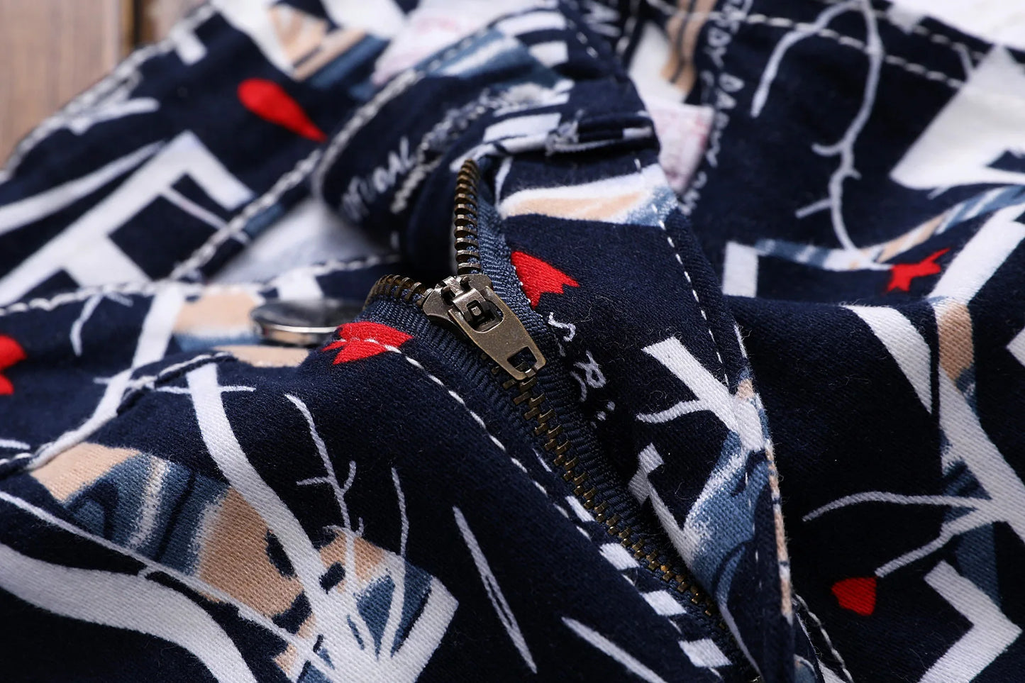 Close-up of a patterned fabric with a zipper, featuring geometric shapes and red accents.