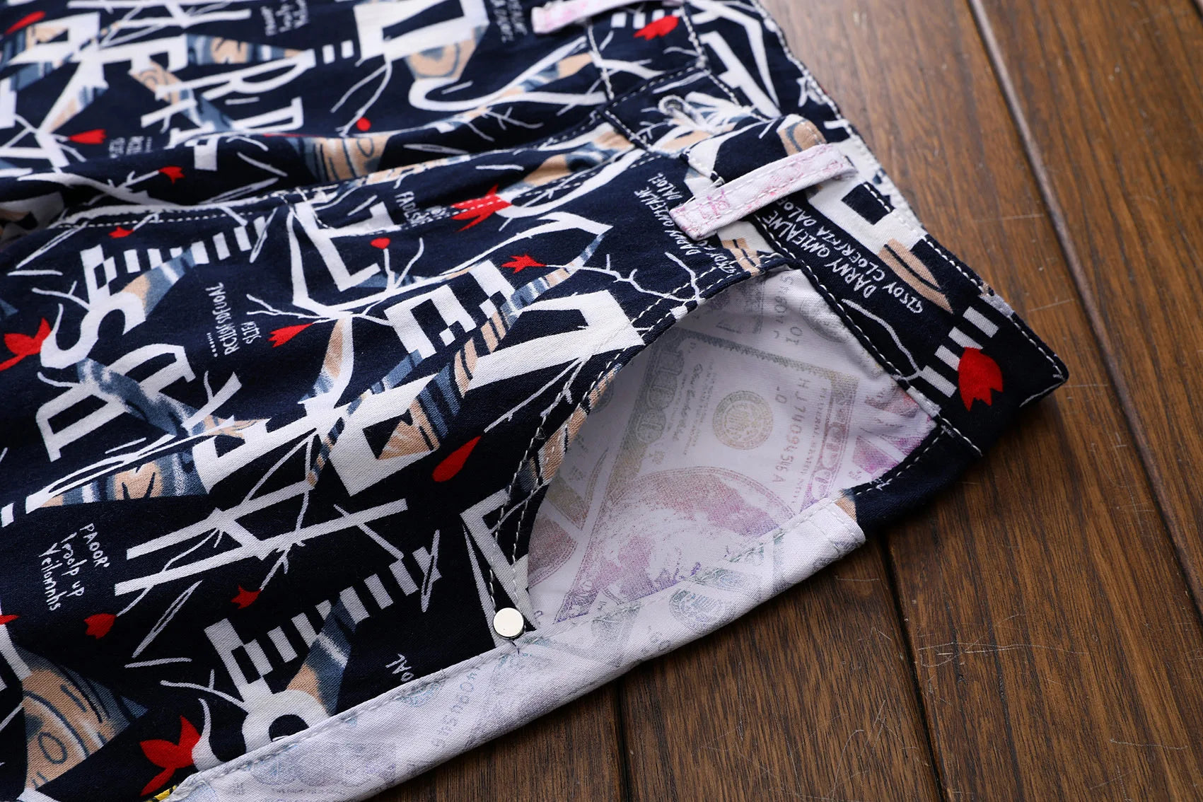Fabric with a pattern of text and red shapes on a wooden surface